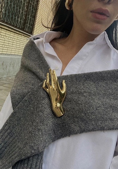 Złota broszka dłoń